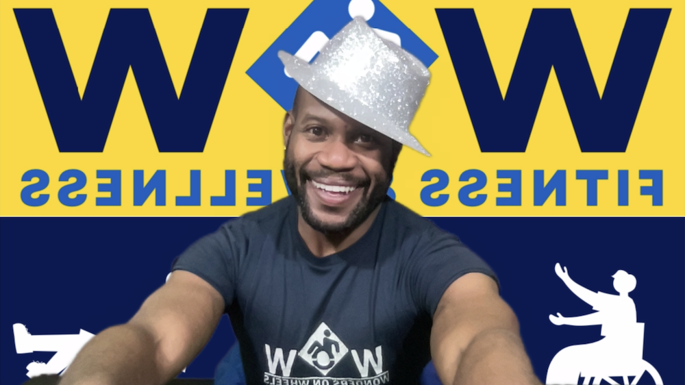 Justin, founder of WOW, smiles at the camera while wearing a blue WOW t-shirt and a fun, sparkly silver fedora hat.