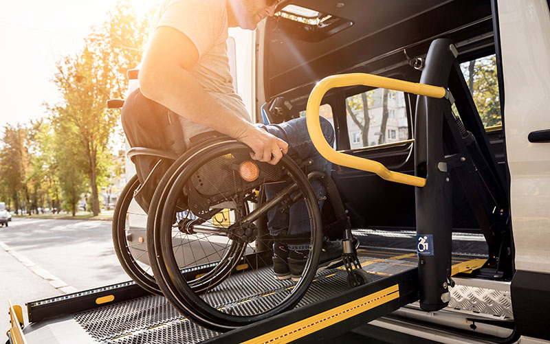 Man entering an accessible van up a ramp