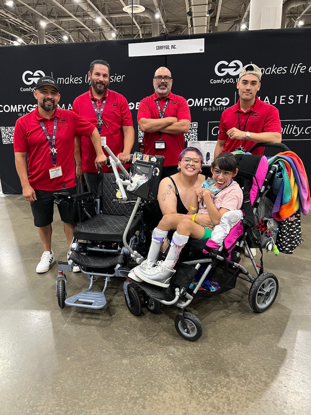 The ComfyGO crew are all smiles as they gather around a mom and her daughter with disabilities, the proud new owners of the Phoenix Carbon Fiber electric wheelchair.