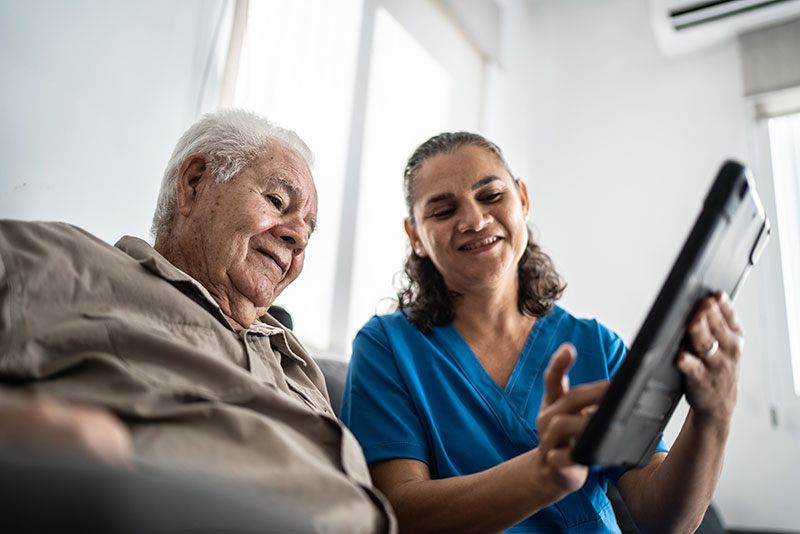 Nurse shows a man technology on a device