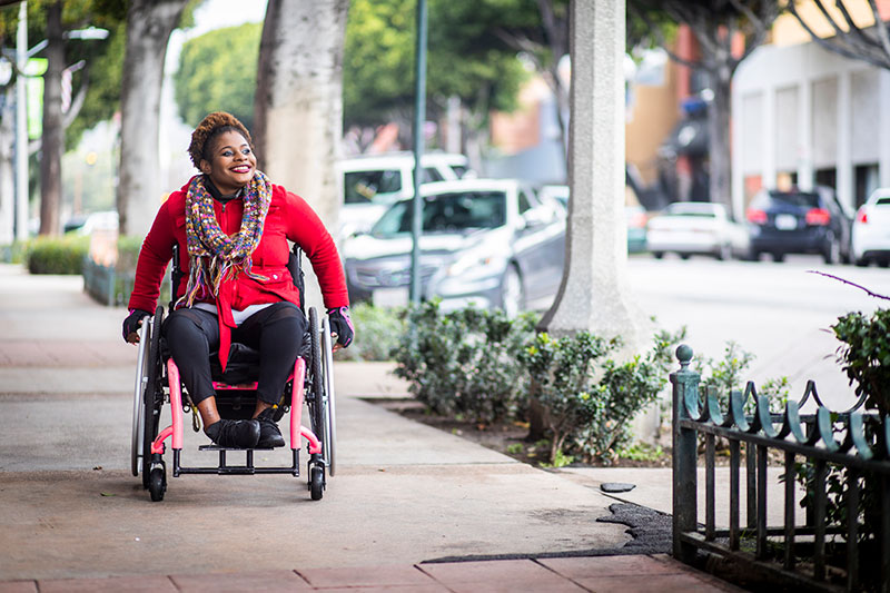 Woman in wheelchair on the sidewalk