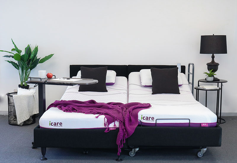 Two twin icare beds are side-by-side to create a queen bed with an over bed table.