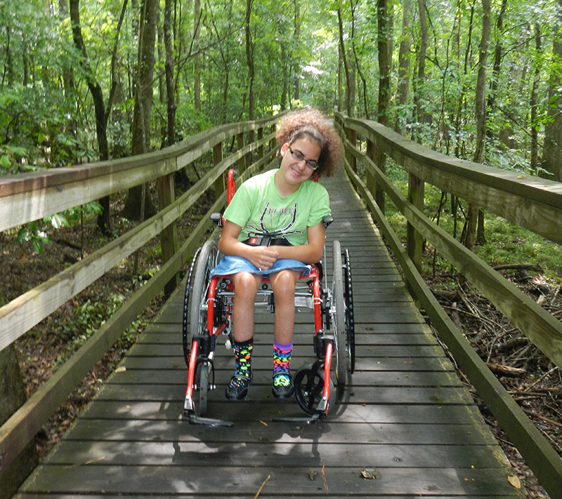 Kelissa on a boardwalk trail in the woods