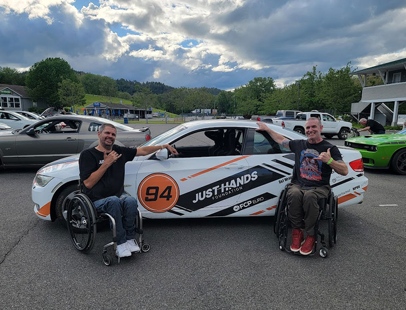 Torsten Gross and a fellow wheelchair user at the racecar track.