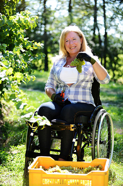 Smiling woman gardening form wheelchair.