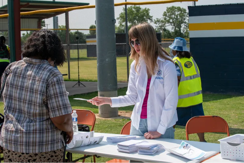 Photo of women behind registration desk at an outreach event.