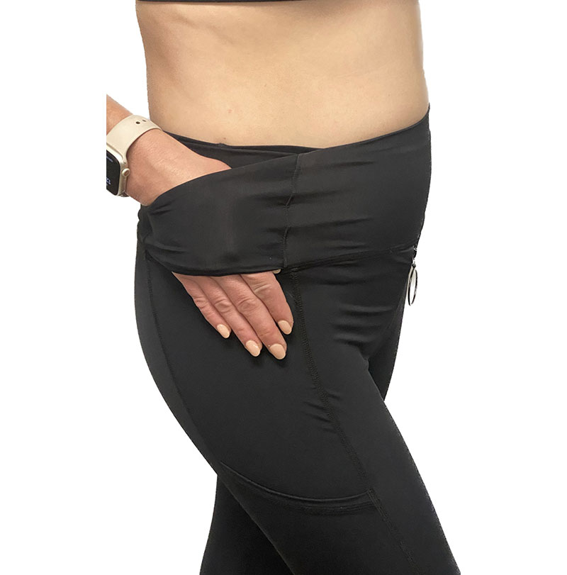 A woman’s thumb is hooked into the round, hollow, accessible zipper pull on a pair of Zip Hers tights.